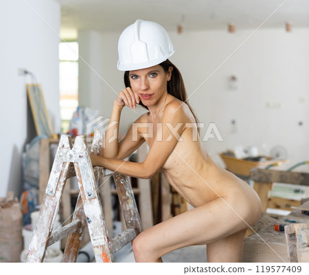 Nude young adult woman posing near ladder 119577409