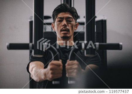 A man in his 40s working out his upper body at the gym A man in his 40s working out his upper body at the gym 119577437
