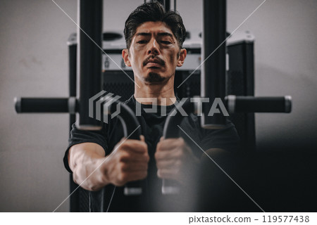 一名40多歲的男子在健身房訓練上半身 一名40多歲的男子在健身房訓練上半身 119577438