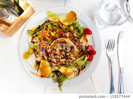Appetizing salad with goat cheese served on plate. Appetizing salad with goat cheese served on plate. 119577444