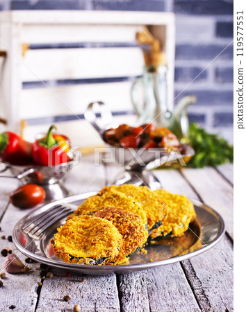 fried fresh zucchini in a plate on the table 119577551