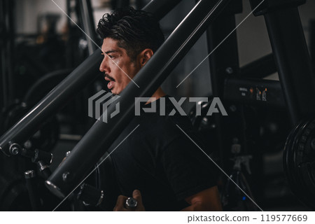 A man using a machine to train his upper body at the gym A man using a machine to train his upper body at the gym 119577669