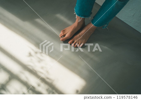 Barefoot woman and window light 119578146