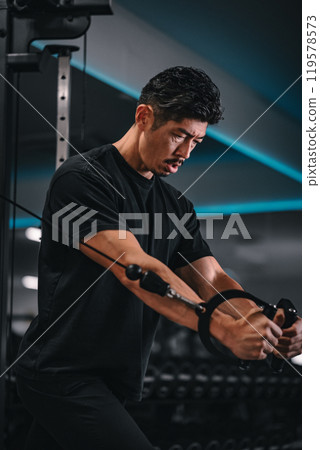 Man using a machine to train at the gym Man using a machine to train at the gym 119578573