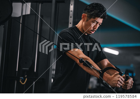 一名男子在健身房使用機器訓練 119578584