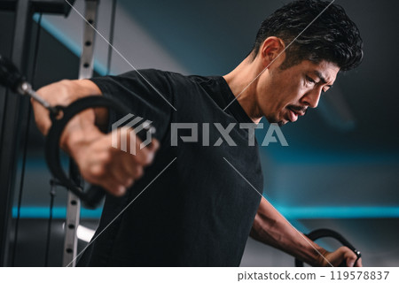 一名男子在健身房使用機器訓練 119578837
