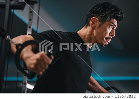 一名男子在健身房使用機器訓練 119578838