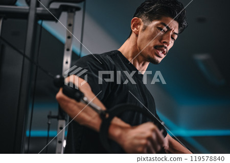 一名男子在健身房使用機器訓練 119578840