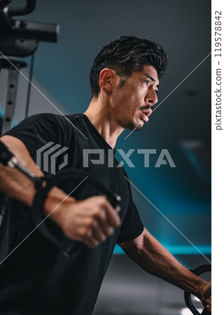 一名男子在健身房使用機器訓練 119578842