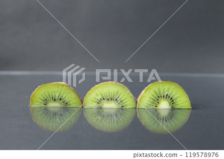 two or three circles of green kiwi semicircle with a black glossy still life two or three circles of green kiwi semicircle with a black glossy still life 119578976