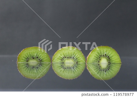 two or three circles of green kiwi semicircle with a black glossy still life two or three circles of green kiwi semicircle with a black glossy still life 119578977