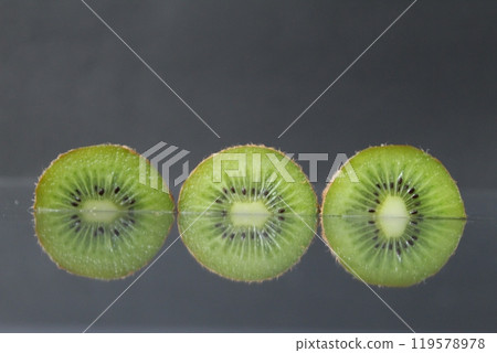 two or three circles of green kiwi semicircle with a black glossy still life two or three circles of green kiwi semicircle with a black glossy still life 119578978