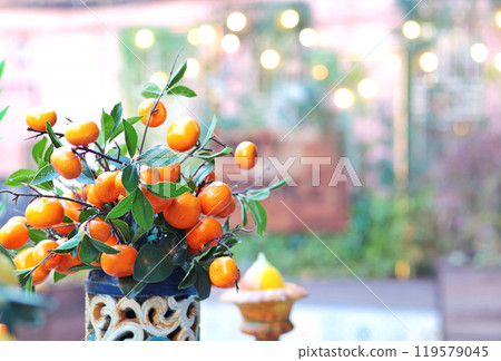 Branch with tangerines in ceramic vase on table. Traditional pattern, Sicily, Italy. Fruit and decor. Branch with tangerines in ceramic vase on table. Traditional pattern, Sicily, Italy. Fruit and decor. 119579045