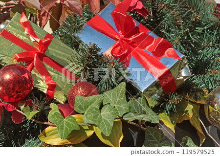 Box with gift, red ribbon and green Christmas tree branch. Holidays and decoration. Box with gift, red ribbon and green Christmas tree branch. Holidays and decoration. 119579525