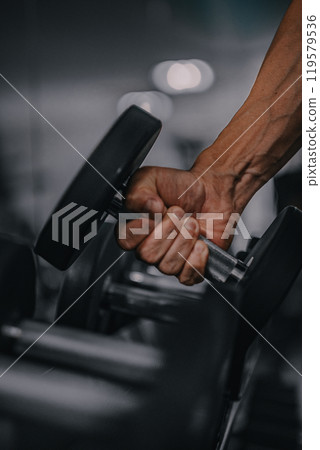 Male arm holding a dumbbell 119579536