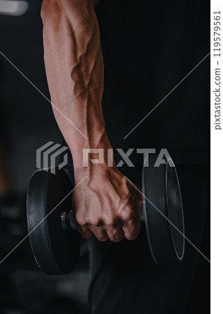 Male arm holding a dumbbell 119579561