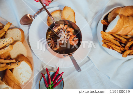 plate soup with sea products with bread as background 119580029