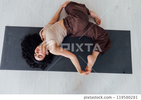 Side view of slim pretty positive young brunette woman doing Utthita parsvakonasana exercise, 119580281