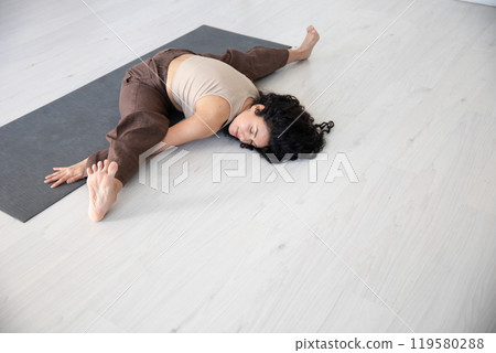 brunette woman doing gymnastics yoga asana 119580288