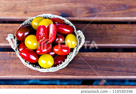 Fresh and colorful cherry tomatoes on dark brown wooden background 119580396