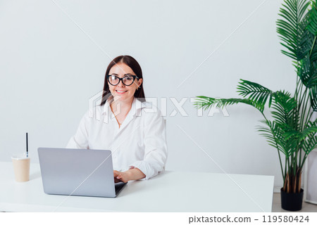 Business woman brunette smiling at work in office with laptop Business woman brunette smiling at work in office with laptop 119580424