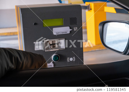 Driver Using Payment Machine at Parking Facility 119581345