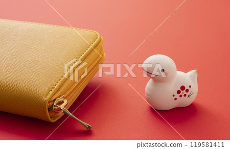 Money matters for the year of the snake. A yellow wallet and a figurine of the zodiac snake. Money matters for the year of the snake. A yellow wallet and a figurine of the zodiac snake. 119581411