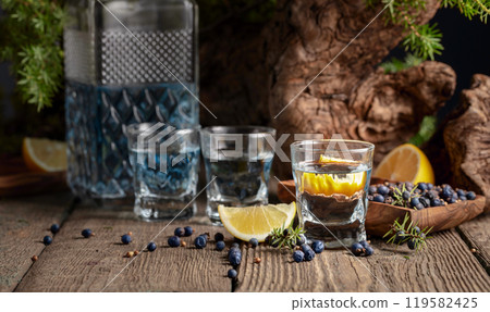Gin with ingredients on an old wooden table. 119582425