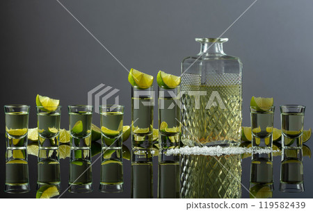 Tequila shots with lime slices and salt on a grey background. 119582439