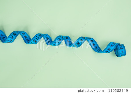 Blue tape measure on the bright light grenn background 119582549