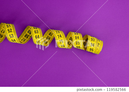 Yellow tape measure on the violet background 119582566