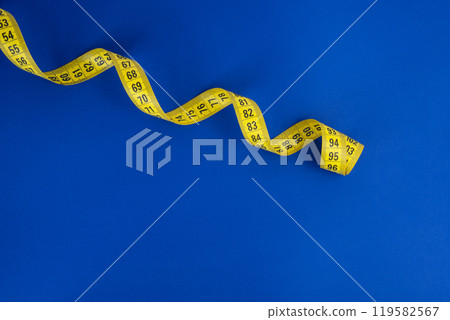 Yellow tape measure on the blue background 119582567