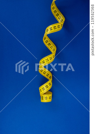 Yellow tape measure on the blue background 119582568