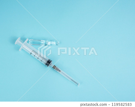 Syringe and ampoule on blue background Syringe and ampoule on blue background 119582583