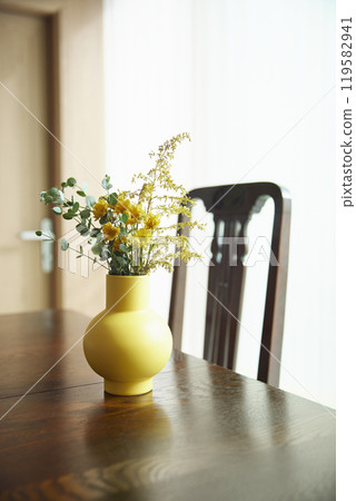 A living room scene with warm sunlight, natural contrast of objects, and relaxed wood tones. 119582941