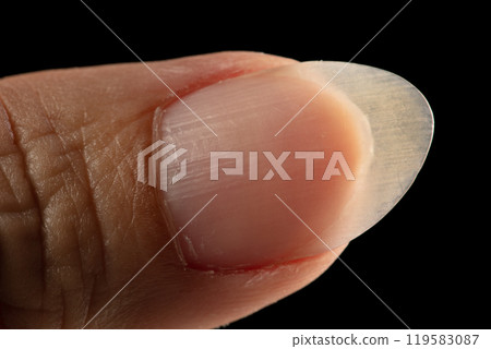 Clean normal long fingernail without color or coating on nail. Long clean fingernail to show texture detail of uneven nail and scratch skin, black background isolated Clean normal long fingernail without color or coating on nail. Long clean fingernail to show texture detail of uneven nail and scratch skin, black background isolated 119583087