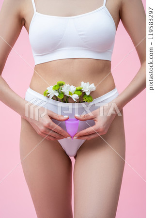 Female wearing absorbent underwear representing menstrual health care holding menstrual cup Female wearing absorbent underwear representing menstrual health care holding menstrual cup 119583297