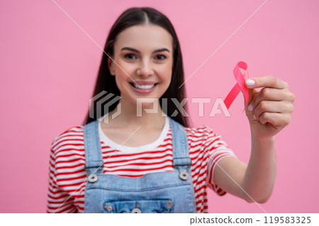 Smiling young woman with pink ribbon participating in a cancer awareness program Smiling young woman with pink ribbon participating in a cancer awareness program 119583325