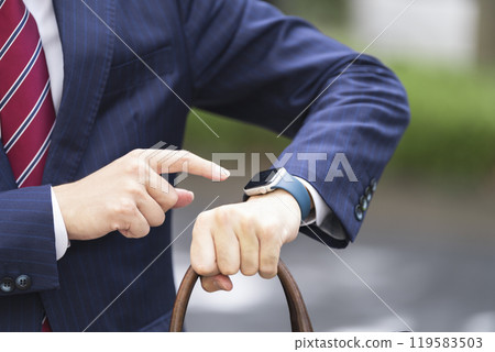 The hand of a businessman pointing at a smartwatch The hand of a businessman pointing at a smartwatch 119583503