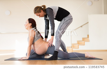 Pregnant woman studies for the Unified State Exam with an instructor in the hall 119583745