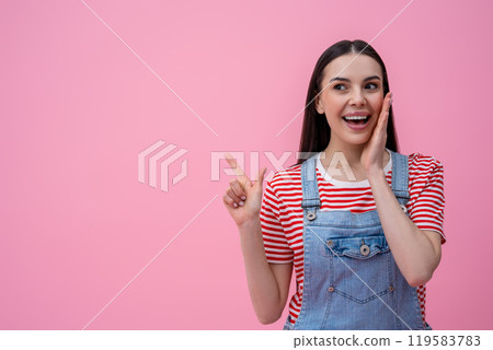 Waist up of a smiling young dark-haired woman in striped tshirt on pink background 119583783