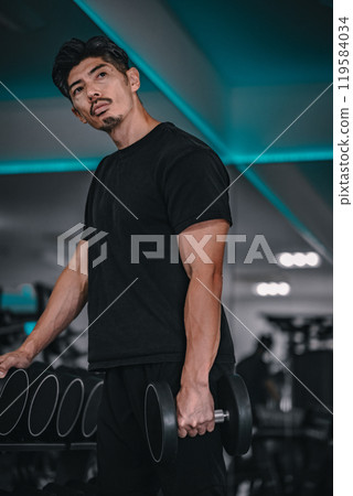 Man holding dumbbells at the gym Man holding dumbbells at the gym 119584034