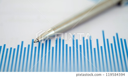 Conducting a thorough analysis of financial trends by using a pen to draw on a chart 119584394
