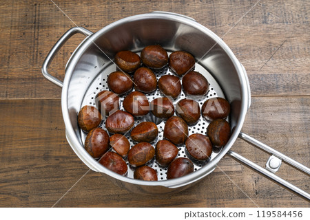 Steaming raw chestnuts in a pressure cooker 119584456