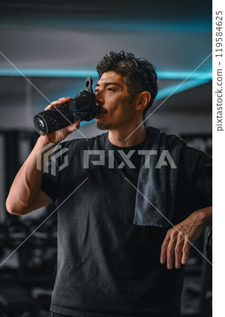 Man taking a break at the gym to hydrate 119584625