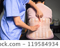 Physiotherapist treat senior women patient orthopedic corset at clinic 119584934