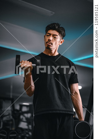 Man training with dumbbells at the gym 119585121