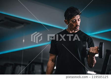 Man training with dumbbells at the gym 119585125