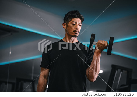 Man training with dumbbells at the gym Man training with dumbbells at the gym 119585129