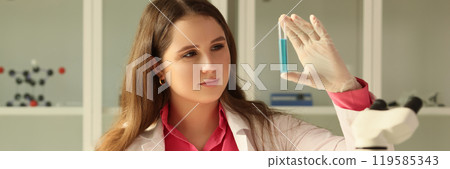 Laboratory worker examines sample of liquid in test tube Laboratory worker examines sample of liquid in test tube 119585343